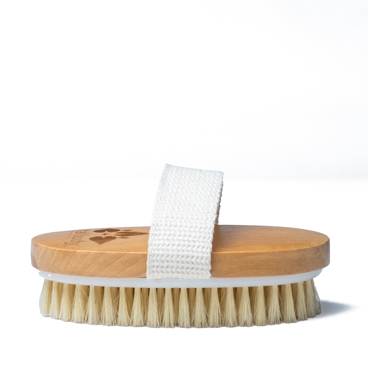Wooden brush with bristles and a white towel on a white background