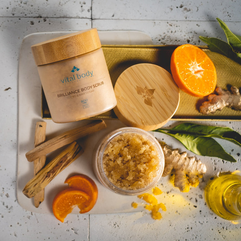 Vital Body Brilliance Body Scrub with ingredients on a white surface