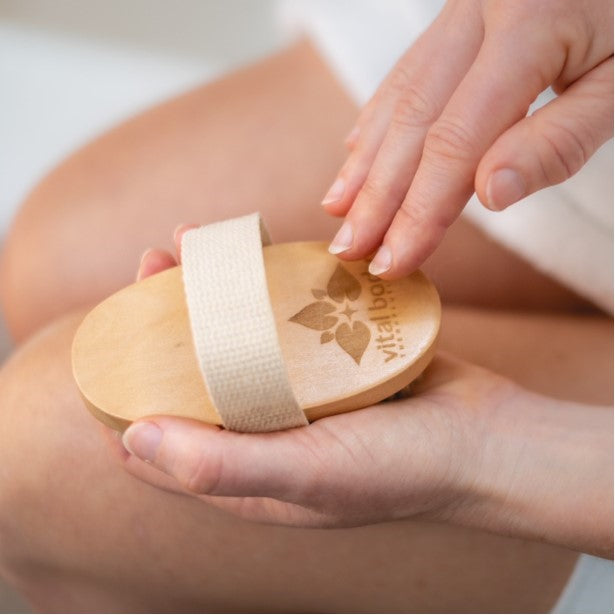 Wooden disc with a bandage on a person's hand, brand 'Vitalia' visible