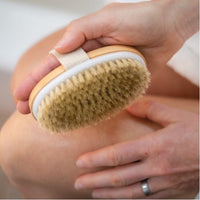 Person using a dry brush on their skin