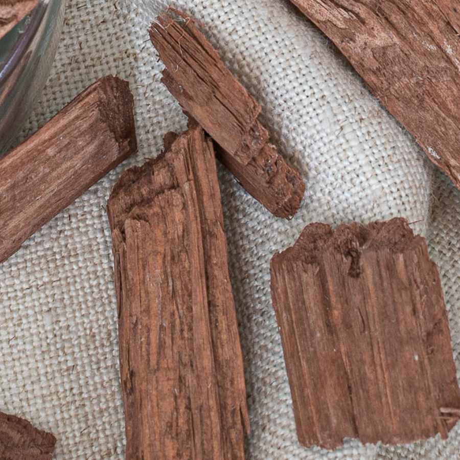 Close-up of cedarwood pieces showing tight, straight grain patterns, with warm reddish-brown and light cream colors, displaying a smooth, natural texture.