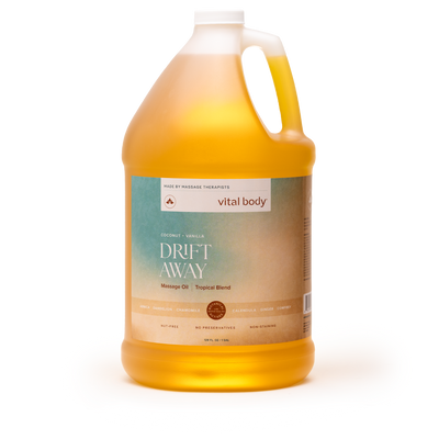 A large plastic jug of vital body Drift Away Manage Oil Tropical Blend, filled with golden yellow oil, on a clean white background.