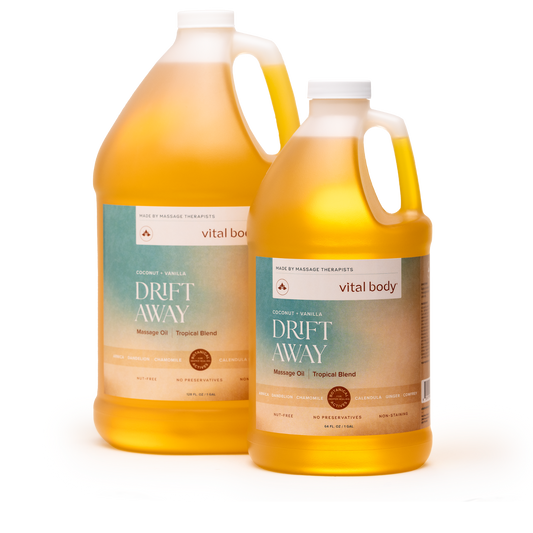 Two plastic gallon jugs of Vital Body Drift Away massage oil with a tropical blend scent, filled with golden yellow oil, on a white background.