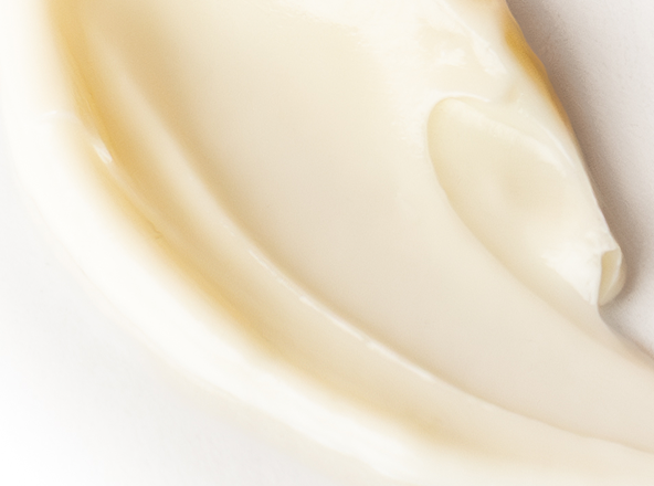 Close-up of a smooth, beige-colored cream on a light background