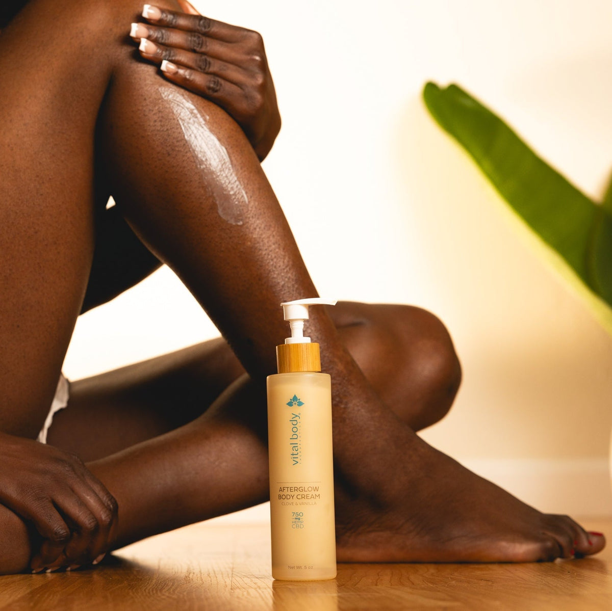 Person applying aftershave body cream to their leg with a bottle of the product in front.