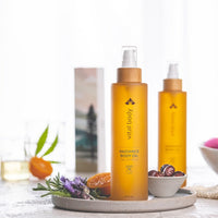 Two bottles of 'vital body' radiance body oil on a decorative tray with lavender and oranges.