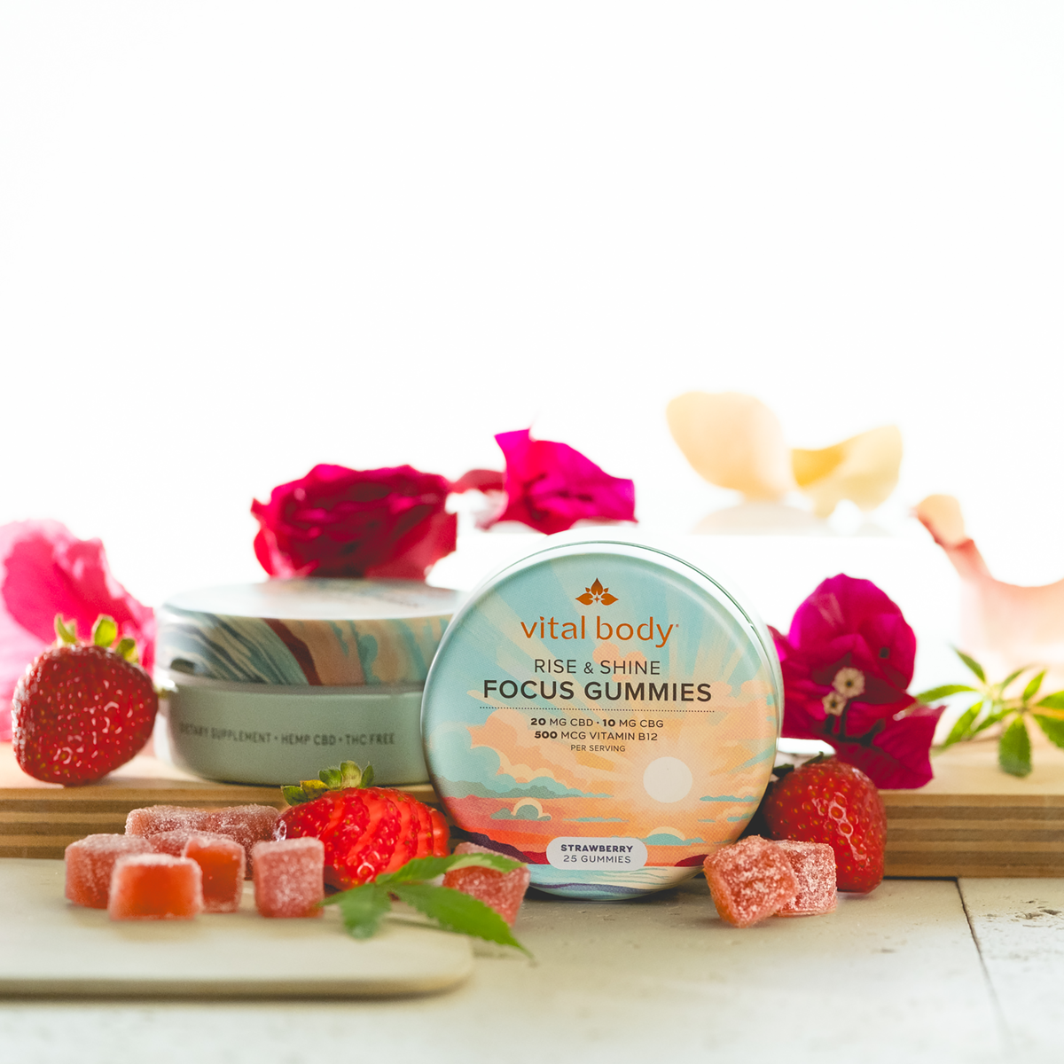 Vital Body Focus Gummies packaging with strawberries and flowers on a white background